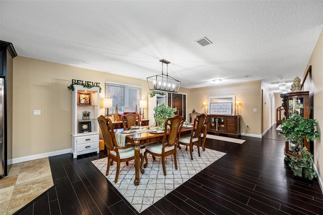 dining room with wood finished floors, a textured ceiling, and baseboards