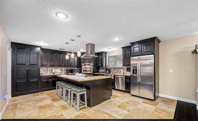 kitchen featuring decorative backsplash, baseboards, appliances with stainless steel finishes, and a center island
