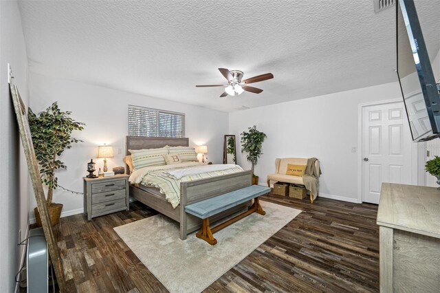 bedroom featuring dark wood-style floors, a textured ceiling, ceiling fan, baseboards, and visible vents