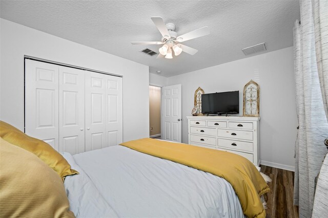 bedroom featuring a closet, wood finished floors, visible vents, and baseboards