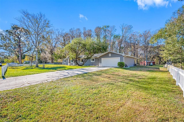 view of front of property featuring an attached garage, fence, driveway, and a front yard