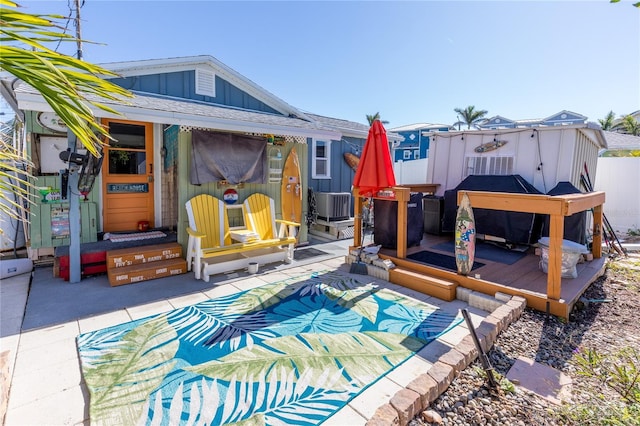 rear view of property featuring a patio area, central air condition unit, and a covered pool