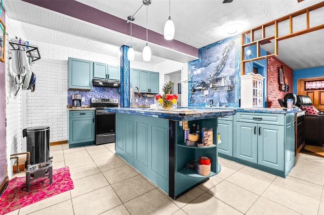 kitchen featuring electric range, hanging light fixtures, brick wall, and blue cabinets