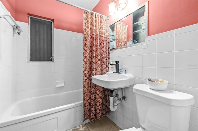 bathroom featuring tile patterned flooring, shower / bath combo, tile walls, and toilet