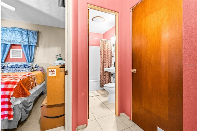 tiled bedroom featuring ensuite bathroom