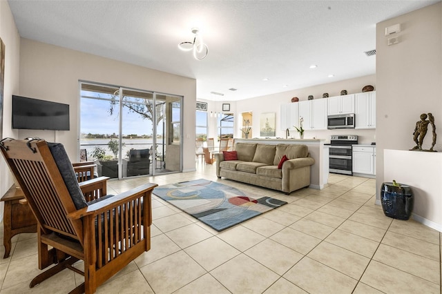 living room with sink, light tile patterned floors, and a textured ceiling