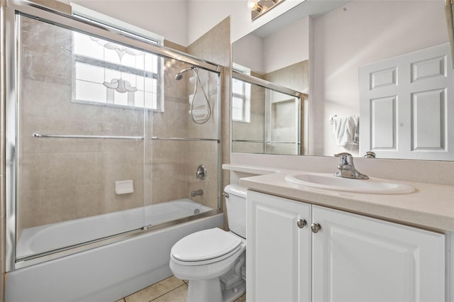 full bathroom with tile patterned floors, toilet, vanity, and combined bath / shower with glass door