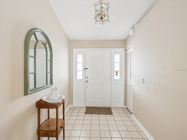 tiled foyer entrance with a textured ceiling