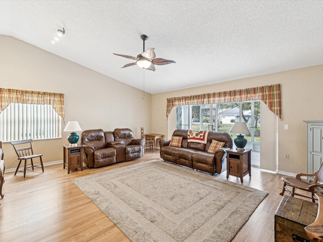 living room with a textured ceiling, ceiling fan, lofted ceiling, and hardwood / wood-style flooring