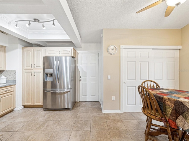 kitchen with backsplash, stainless steel refrigerator with ice dispenser, ceiling fan, a textured ceiling, and light tile patterned flooring