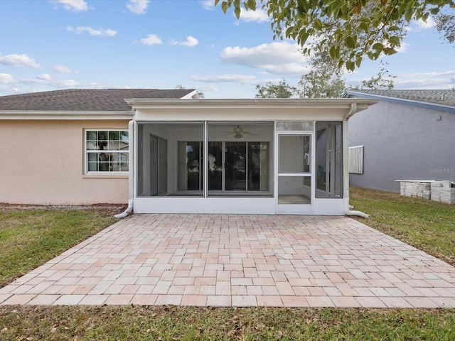 rear view of house with a sunroom, a patio area, and a lawn