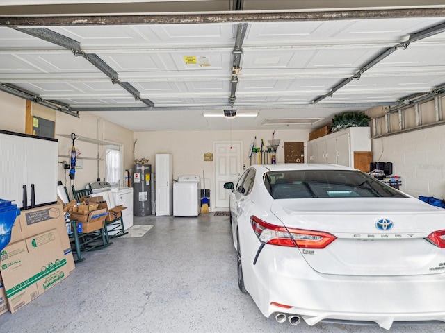 garage with electric water heater, a garage door opener, and independent washer and dryer