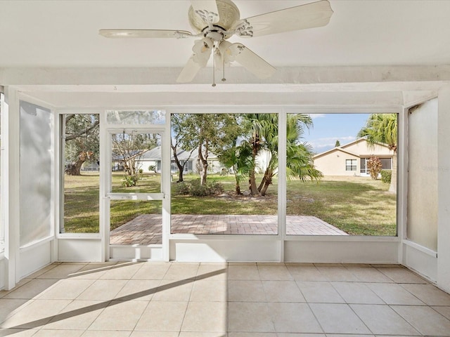 unfurnished sunroom featuring ceiling fan