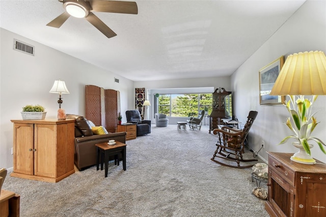 carpeted living room with ceiling fan