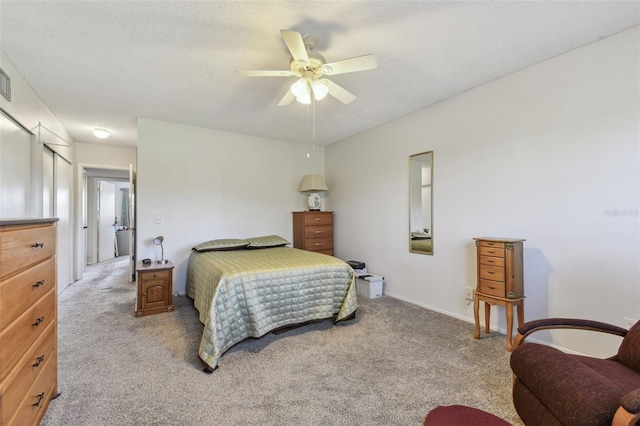 carpeted bedroom featuring a textured ceiling and ceiling fan