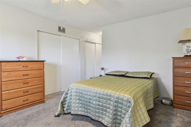 bedroom featuring carpet flooring, ceiling fan, and a textured ceiling