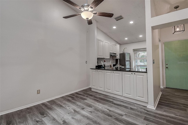 kitchen with stainless steel refrigerator, ceiling fan, light hardwood / wood-style floors, lofted ceiling, and white cabinets