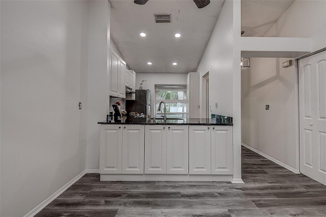 kitchen featuring dark hardwood / wood-style flooring, ceiling fan, sink, white cabinetry, and stainless steel refrigerator