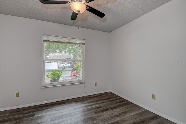 spare room featuring ceiling fan, dark wood-type flooring, and a textured ceiling