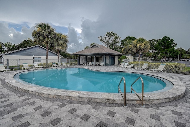 view of swimming pool with an outdoor structure and a patio area