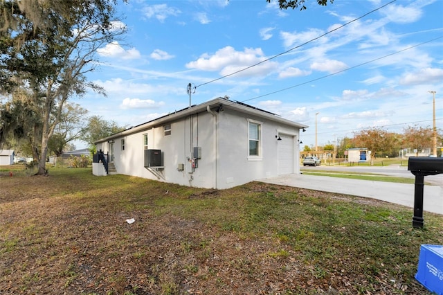 view of side of home featuring a lawn and a garage