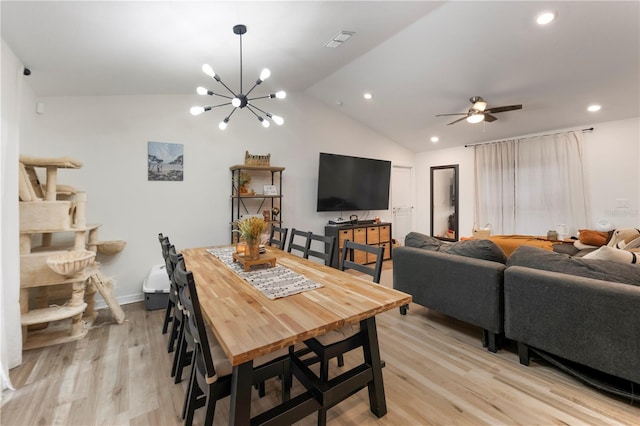 dining area featuring vaulted ceiling, ceiling fan with notable chandelier, and light hardwood / wood-style flooring