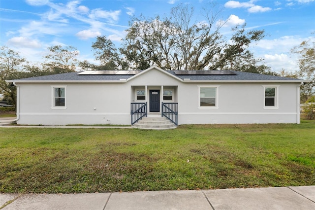 view of front of home with a front lawn and solar panels