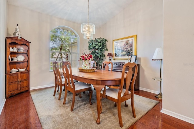 dining room with wood-type flooring and an inviting chandelier