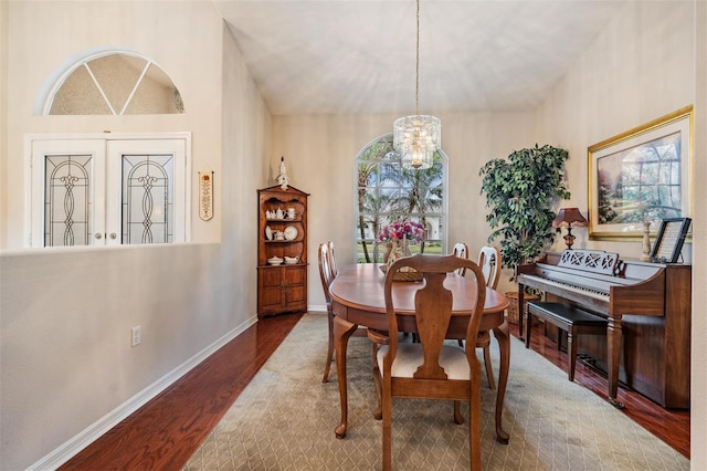 dining area featuring hardwood / wood-style floors and an inviting chandelier