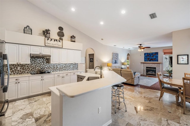 kitchen featuring ceiling fan, sink, white cabinetry, and backsplash