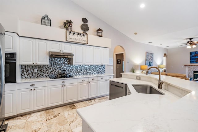 kitchen featuring white cabinets, a tiled fireplace, black appliances, and sink