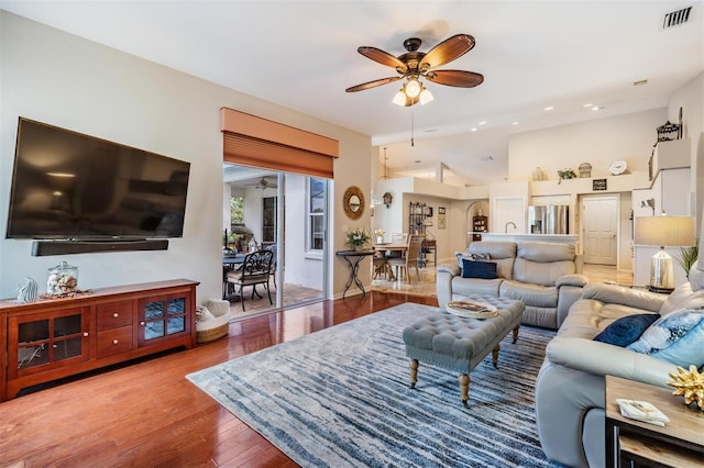 living room with ceiling fan and light wood-type flooring