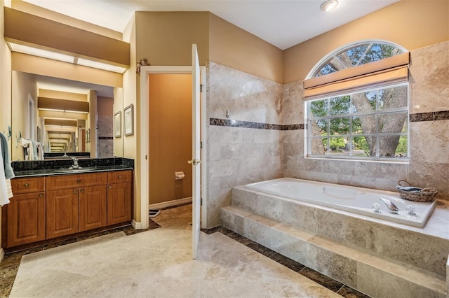 bathroom with vanity and a relaxing tiled tub