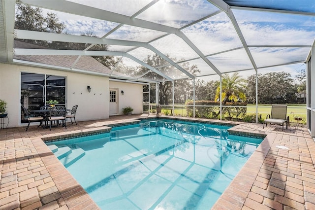 view of swimming pool with glass enclosure and a patio area