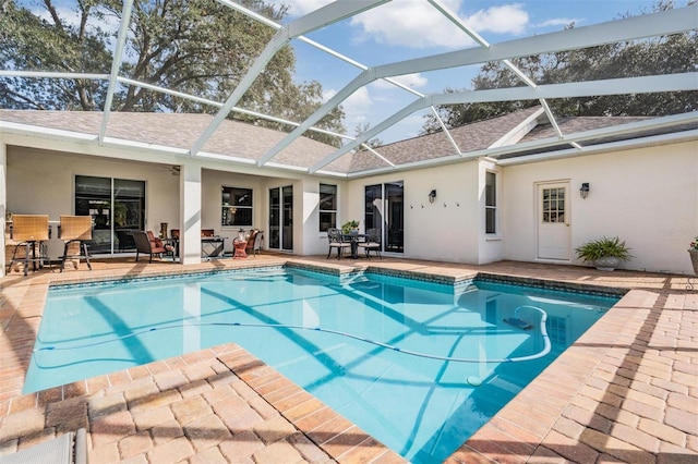 view of swimming pool featuring a patio and glass enclosure