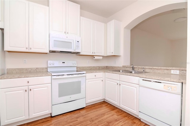 kitchen with white cabinets, white appliances, light hardwood / wood-style flooring, and sink