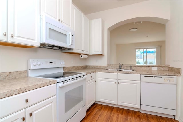 kitchen featuring sink, white cabinets, light hardwood / wood-style floors, and white appliances