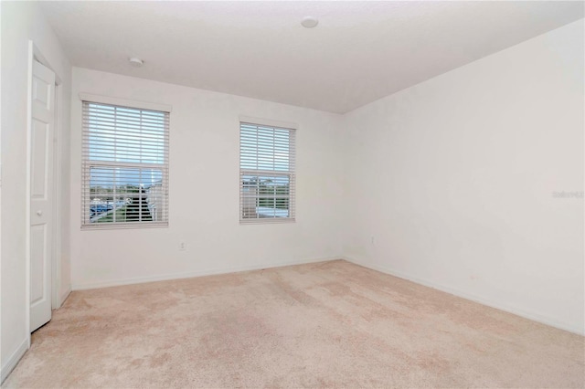 unfurnished room featuring light carpet