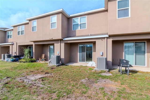 back of property featuring a lawn and central AC