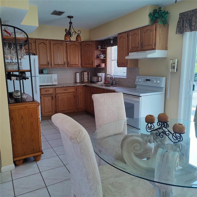 kitchen featuring light tile patterned flooring, white appliances, backsplash, and sink