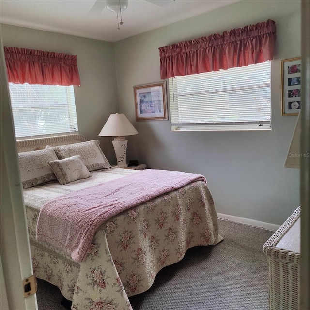 carpeted bedroom with multiple windows and ceiling fan