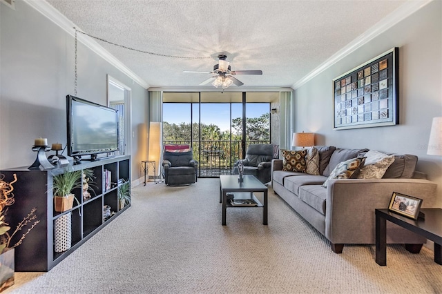 carpeted living room with ceiling fan, ornamental molding, a textured ceiling, and a wall of windows