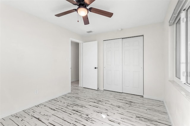 unfurnished bedroom with light wood-type flooring, a closet, and ceiling fan