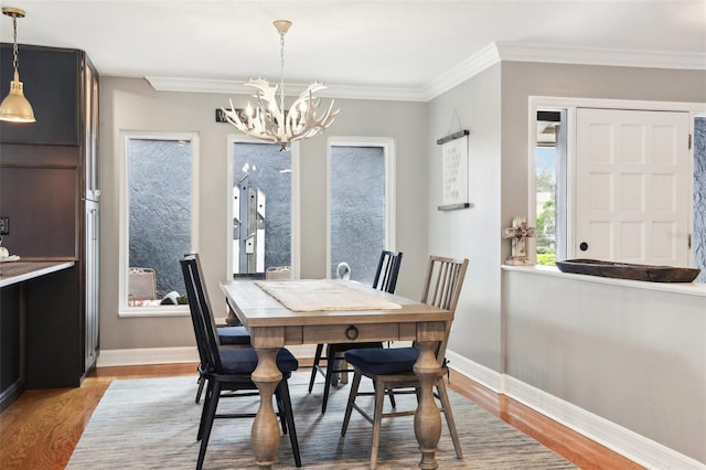 dining room with a chandelier, hardwood / wood-style flooring, and ornamental molding