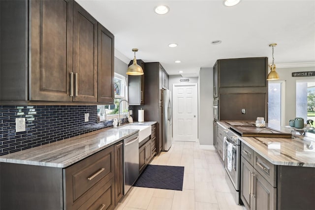 kitchen featuring a healthy amount of sunlight, light stone countertops, hanging light fixtures, and appliances with stainless steel finishes