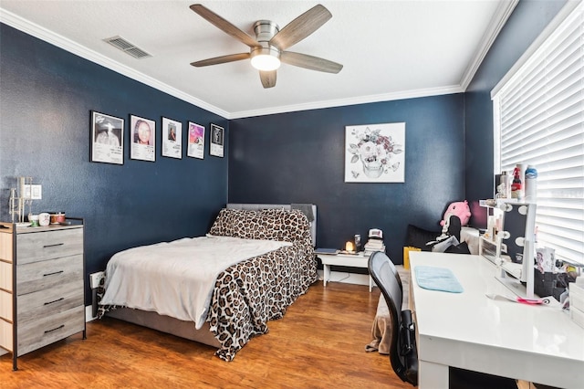 bedroom featuring hardwood / wood-style flooring, ceiling fan, and crown molding