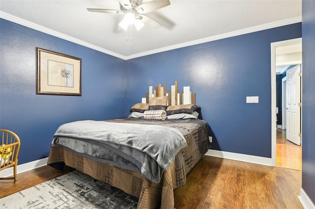 bedroom featuring hardwood / wood-style floors, ceiling fan, and crown molding