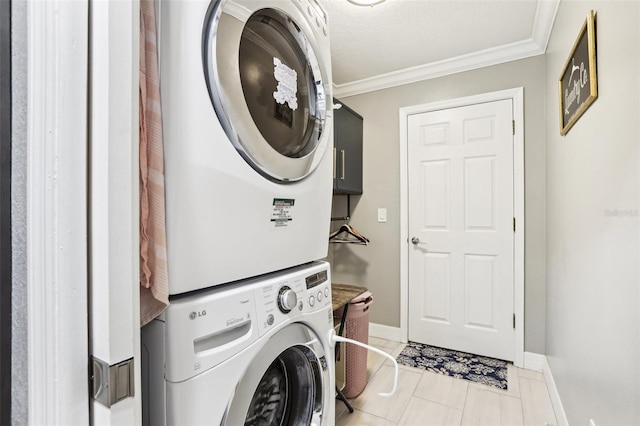 clothes washing area featuring a textured ceiling, stacked washer / dryer, crown molding, and light tile patterned flooring