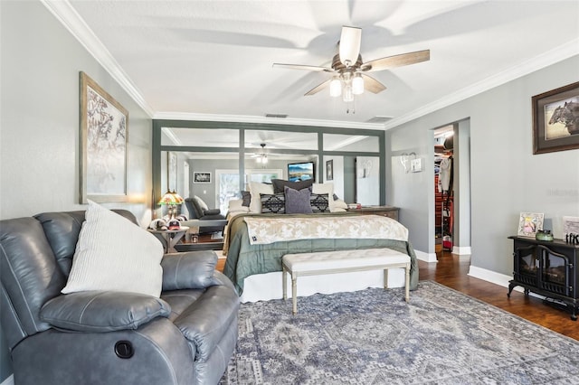 bedroom with a wood stove, ceiling fan, dark hardwood / wood-style flooring, and crown molding