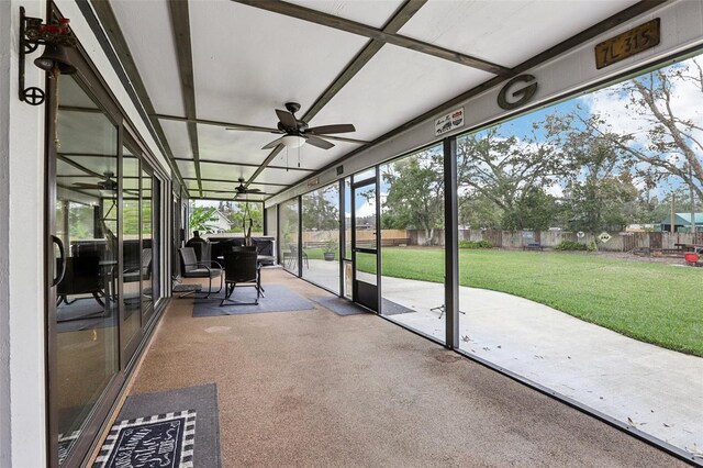 unfurnished sunroom featuring ceiling fan